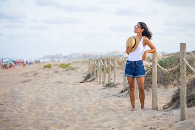 Jonge vrouw die zich op het strand bevindt