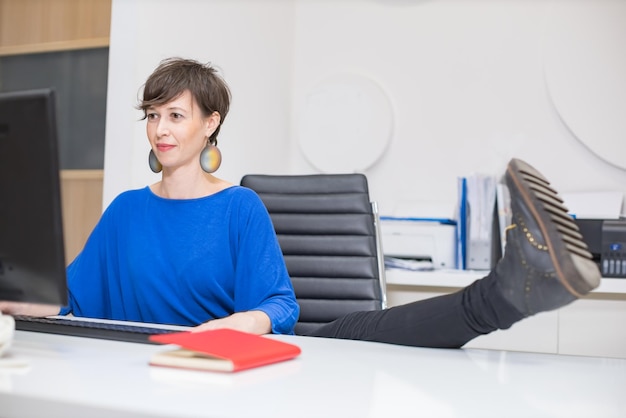 Jonge vrouw die zich uitstrekt in het kantoor tijdens de rem