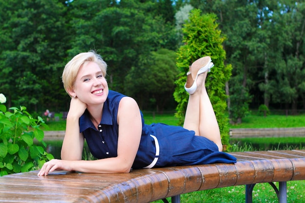 Jonge vrouw die zich voordeed op een bankje in een stadspark