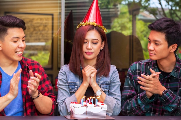 Jonge vrouw doet een wens op verjaardagsfeestje