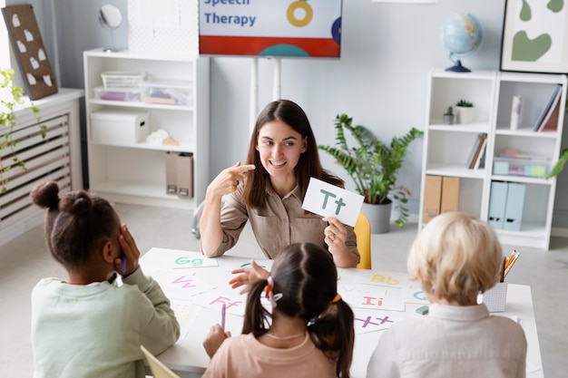 Foto jonge vrouw doet logopedie met kinderen in haar kliniek