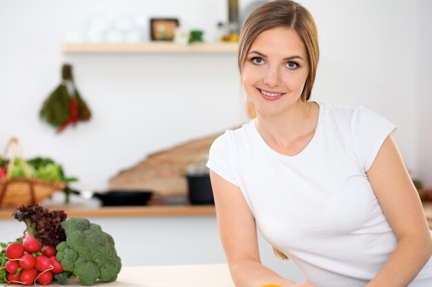 Jonge vrouw doet online winkelen met tabletcomputer en creditcard Huisvrouw heeft nieuw recept gevonden om in een keuken te koken