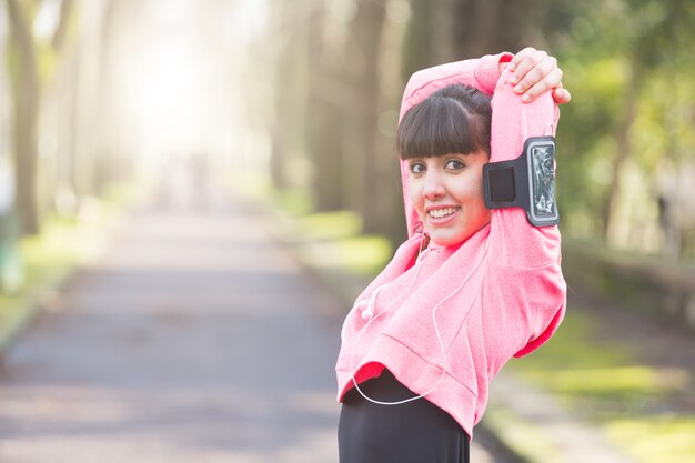 Jonge vrouw doet wapens en schouders Stretching oefeningen.