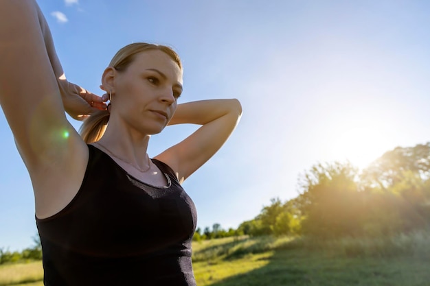 Jonge vrouw doet warming-up voordat ze gaat sporten Het concept van een gezonde levensstijl