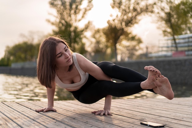 Foto jonge vrouw doet yoga aan het meer