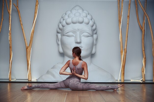 Jonge vrouw doet yoga oefening in de studio