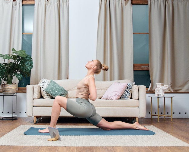 Jonge vrouw doet yoga-oefening in een kamer thuis