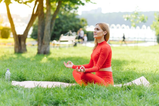 Jonge vrouw doet yoga oefening in groen park