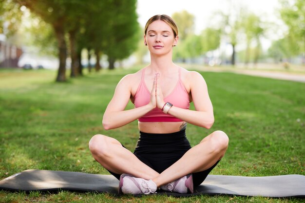 Jonge vrouw doet yoga oefeningen in het park