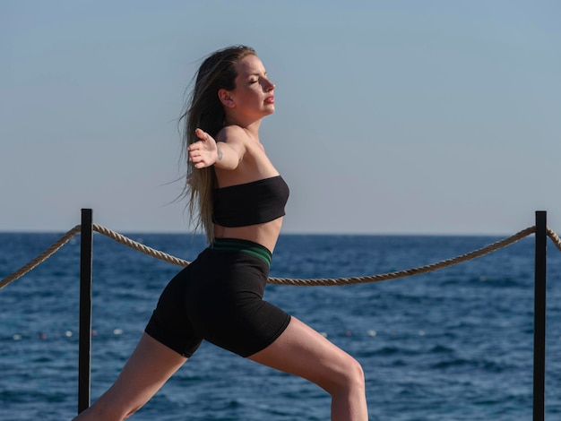 Jonge vrouw doet yoga op het strand