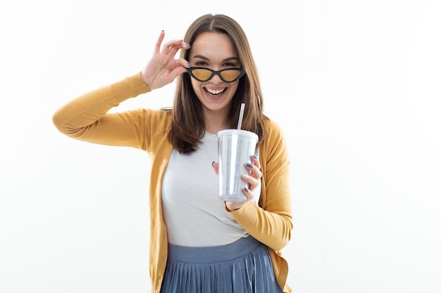 Jonge vrouw drinkt limonade uit een briljant groot glas