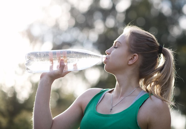 Foto jonge vrouw drinkt water uit een fles