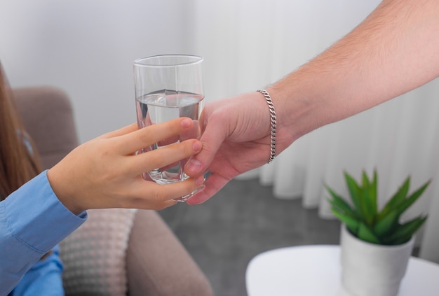 Jonge vrouw drinkt water uit een glas