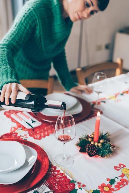 jonge vrouw een glas gieten met rode wijn