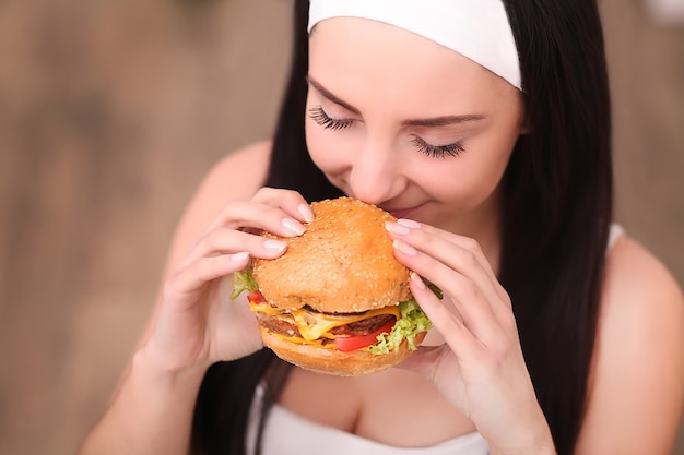 Jonge vrouw eet een hamburger