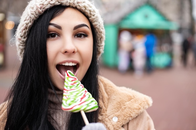 Jonge vrouw eet snoep terwijl ze op de wintervakantie staat