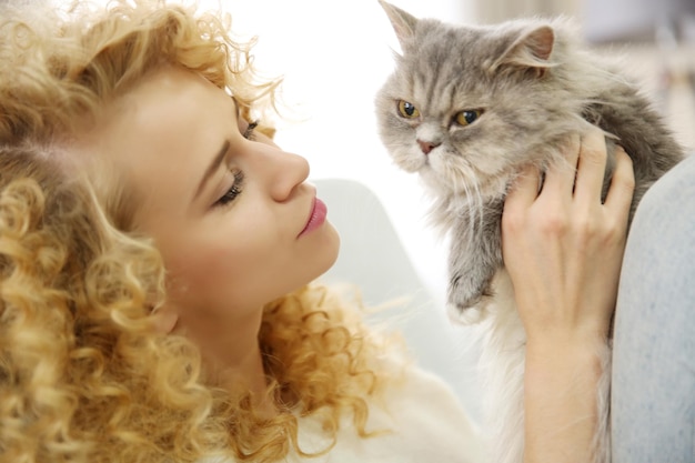 Jonge vrouw en kat op de bank in de kamer