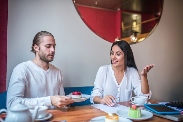 Jonge vrouw en man aan het werk in een klein restaurant