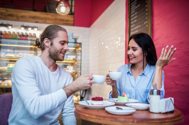 Jonge vrouw en man die dessert in een restaurant proeven