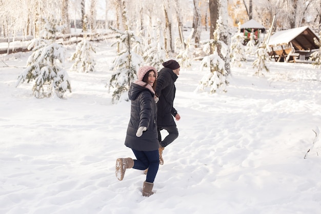 Jonge vrouw en man verliefd uitgevoerd op een besneeuwde winterbos