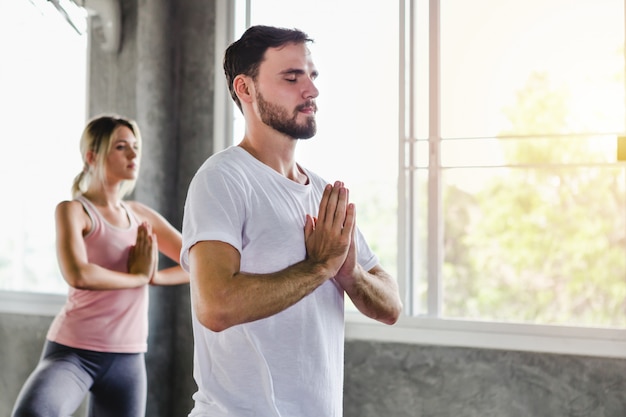 Jonge vrouw en mannen die training van het levensstijl de gezonde lichaam in gymnastiek opleiden