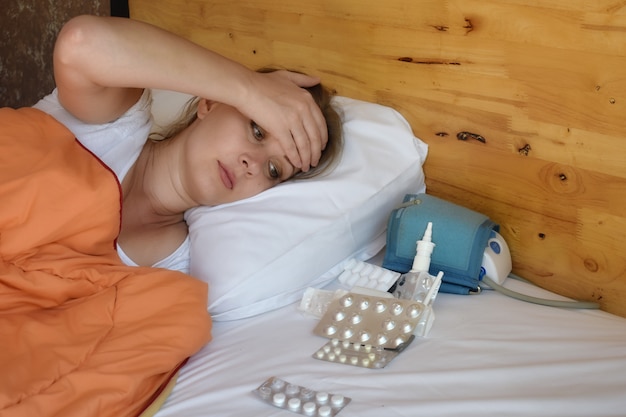 jonge vrouw en medicijnen op het bed