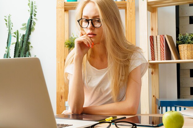 Jonge vrouw en tablet die thuis bureau werken.