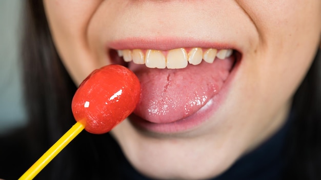 Jonge vrouw flirt meisje met lolly Sexy vrouw met lippen houden lolly schoonheid closeup