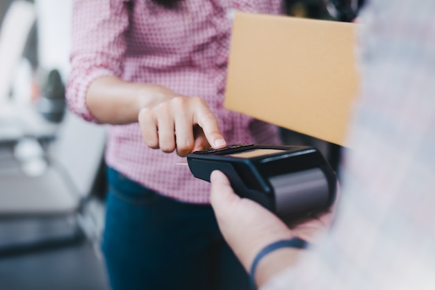 Foto jonge vrouw gebruikt een creditcard om goederen te betalen