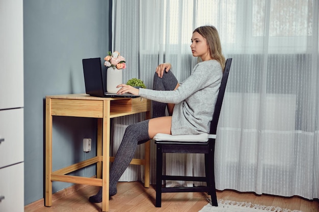 Jonge vrouw gebruikt laptop om thuis te telewerken