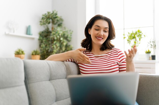 Jonge vrouw gebruikt laptop pc voor gesprek op afstand met vrienden Grappig meisje met plezier