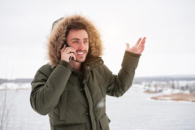 Foto jonge vrouw gebruikt telefoon terwijl ze op sneeuw staat