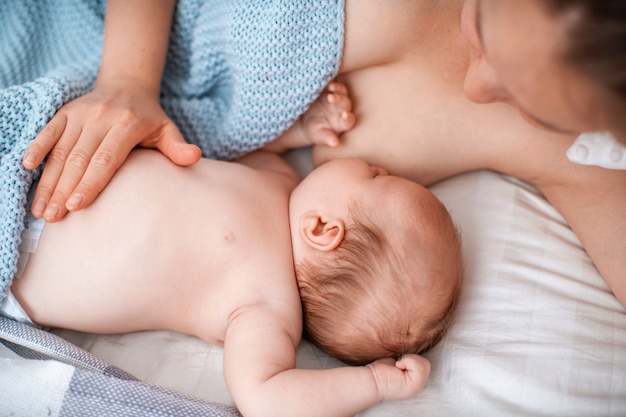 jonge vrouw geeft een baby borstvoeding. Concept van pasgeboren borstvoeding.