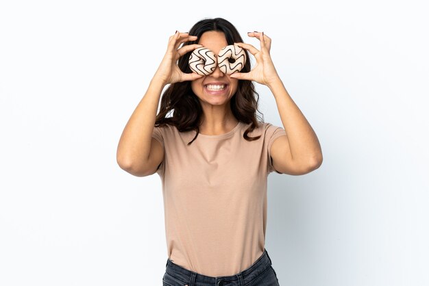 Jonge vrouw geïsoleerd donuts in de ogen te houden