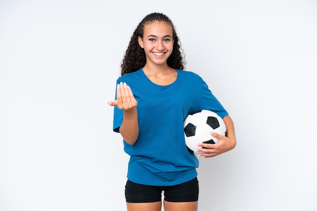 Jonge vrouw geïsoleerd op een witte achtergrond met voetbal en komend gebaar doen