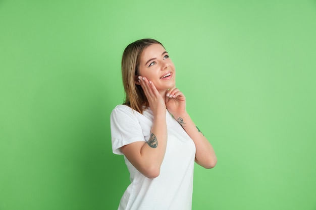 Jonge vrouw geïsoleerd op groene studio wall