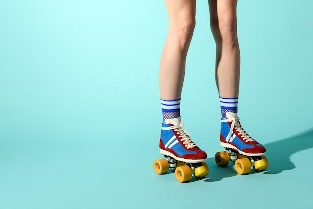 Jonge vrouw, gekleed in kleurrijke rolschaatsen met sexy enkel hoge fishnet sokken