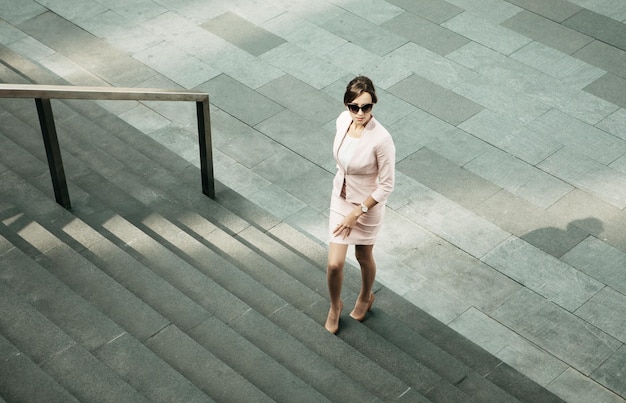 Jonge vrouw gekleed in zakelijke stijl naast het trappenbedrijf en carrièreconcept