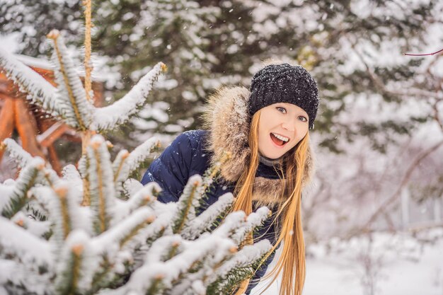 Jonge vrouw geniet van een besneeuwde winterdag in een besneeuwd bos