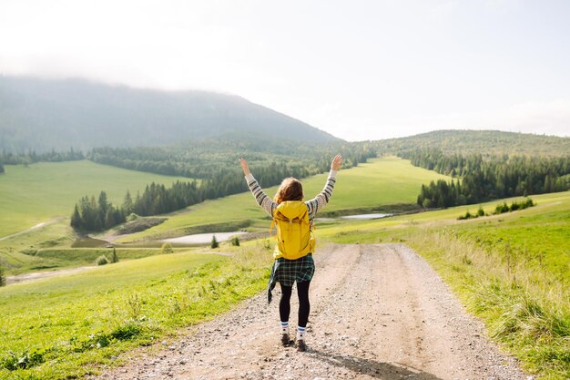 Jonge vrouw geniet van een wandeling door de vallei met een prachtig natuurlijk panorama avontuur concept