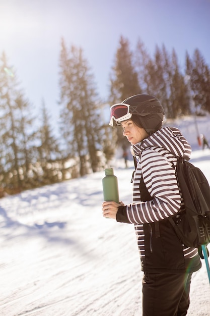 Jonge vrouw geniet van winterdag van skiplezier in de sneeuw