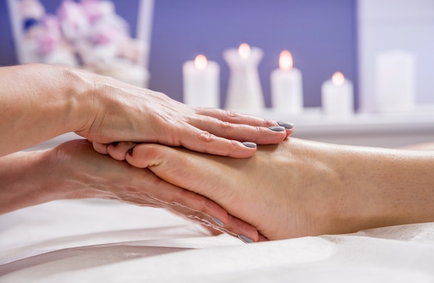 jonge vrouw genieten van voetmassage in spa salon. Cosmetologie