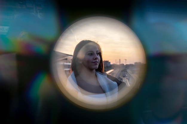 Jonge vrouw gezien door apparatuur tegen de hemel tijdens zonsondergang