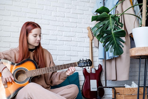 Jonge vrouw gitaar spelen thuis