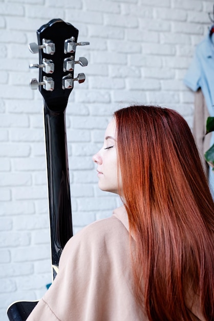 Jonge vrouw gitaar spelen thuis