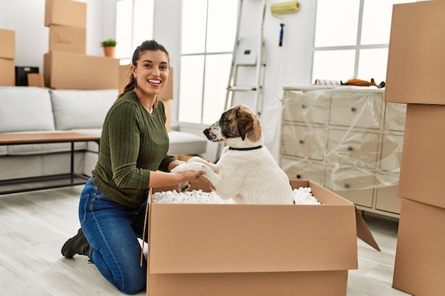 Jonge vrouw glimlachend zelfverzekerd spelen met hond thuis