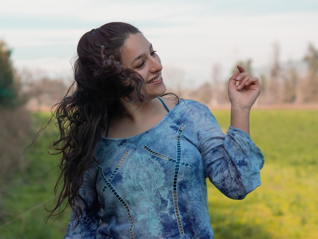 Foto jonge vrouw glimlacht terwijl ze op het veld staat