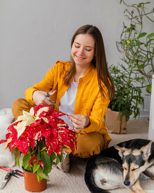 Foto jonge vrouw haar planten binnenshuis verzorgen