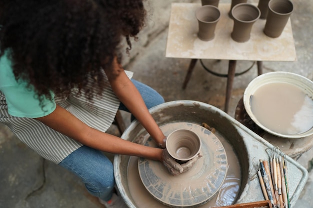 Jonge vrouw hand pottenbakker klei vaas maken in aardewerk workshop Bedrijfseigenaar