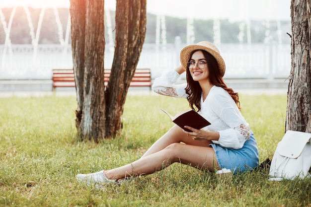 Jonge vrouw hebben weekend en zit overdag in het park